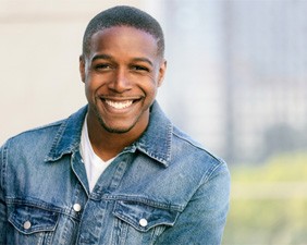 Man smiling outside after visiting cosmetic dentist in Pacoima