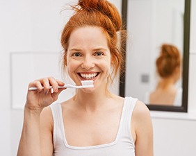 young woman brushing teeth