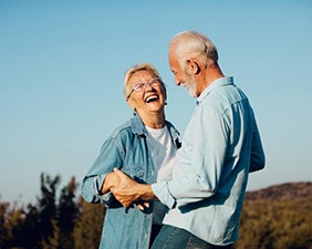 Couple laughing together on a hill