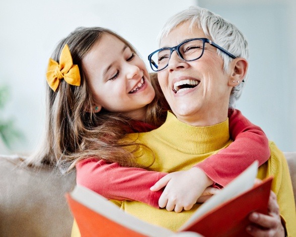 Woman smiling at granddaughter enjoying the benefits of dental implants