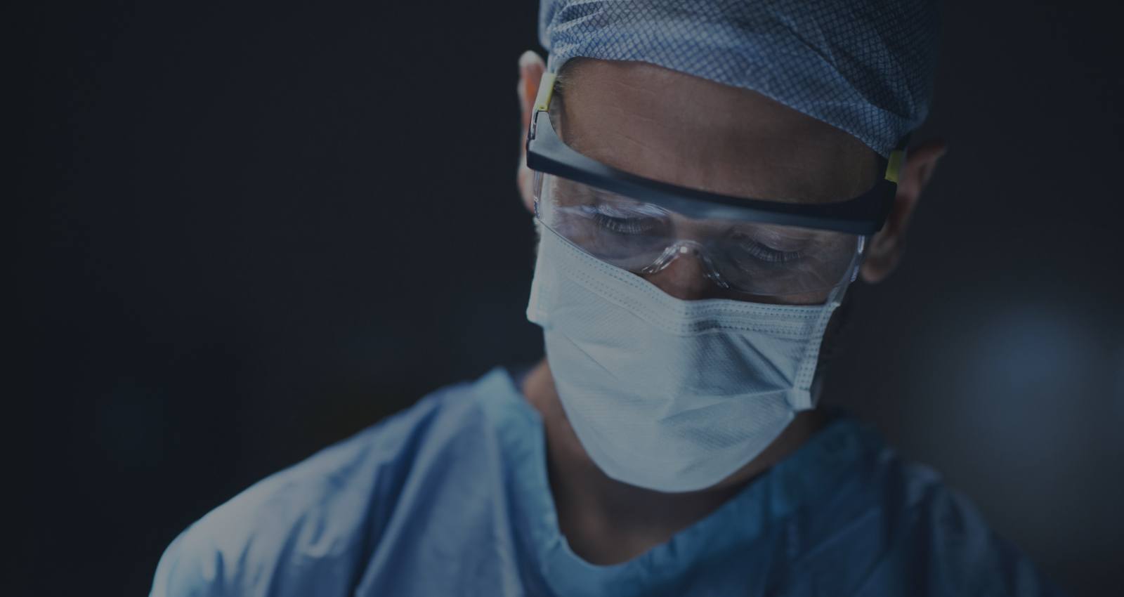 Dentist wearing surgical equipment treating a patient
