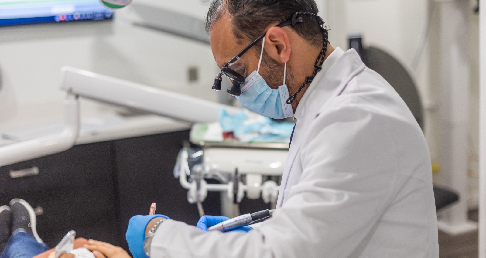 Dental team member pointing to dental x rays on computer screen