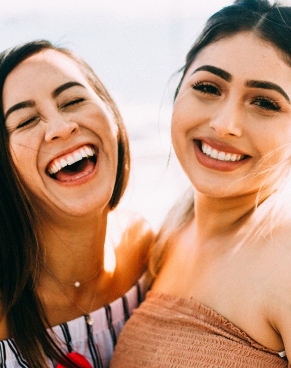 Two young women laughing together outdoors