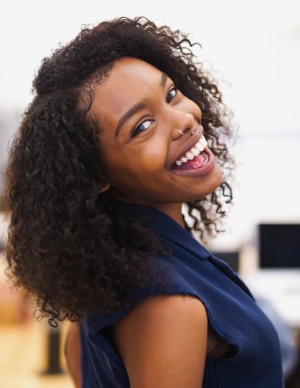 Woman in blue blouse grinning outdoors