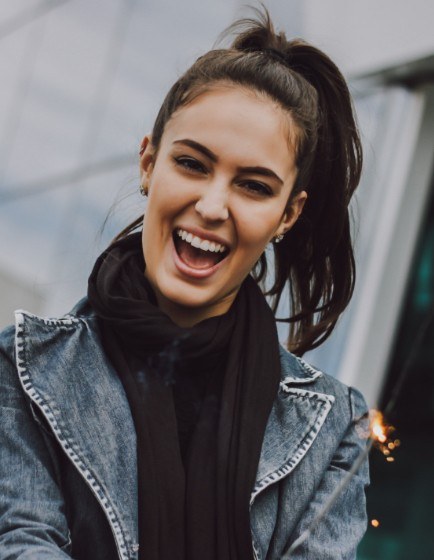 Woman with ponytail and scarf smiling