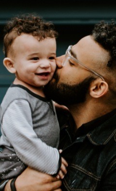 Man kissing baby on cheek