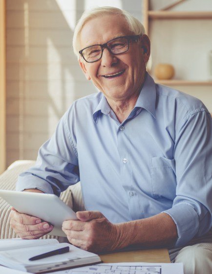 Older man smiling after replacing missing teeth