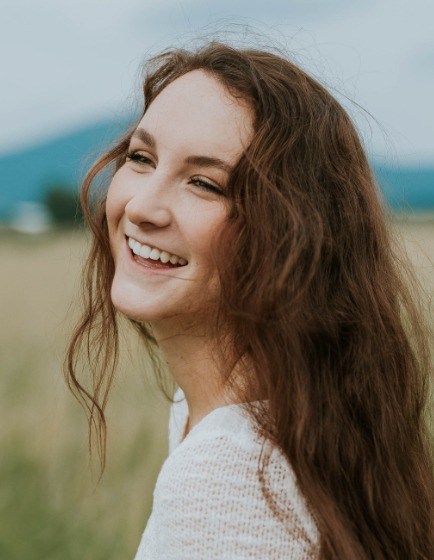 Young woman with aligned smile after orthodontic treatment