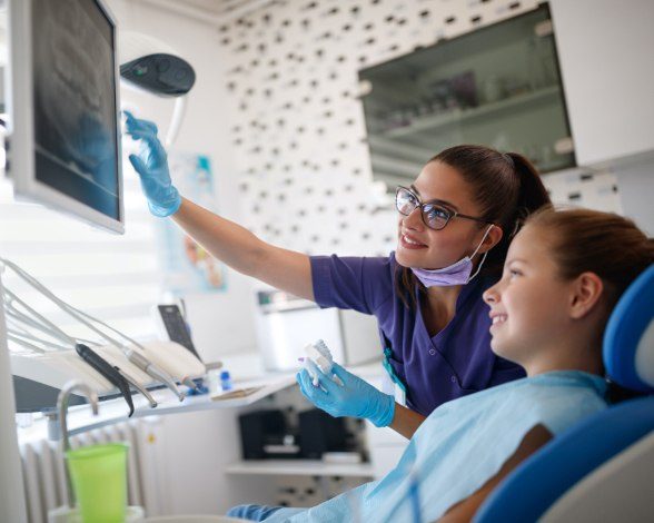 Dentist and young patient looking at digital x-rays