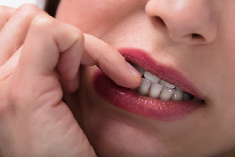 young woman biting fingernails