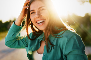 Young woman outside in park during summer smiling