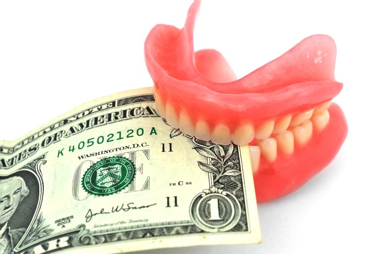 Dentures biting a dollar bill