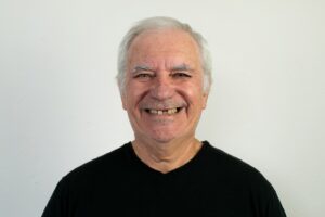 Older man smiling with missing front teeth.